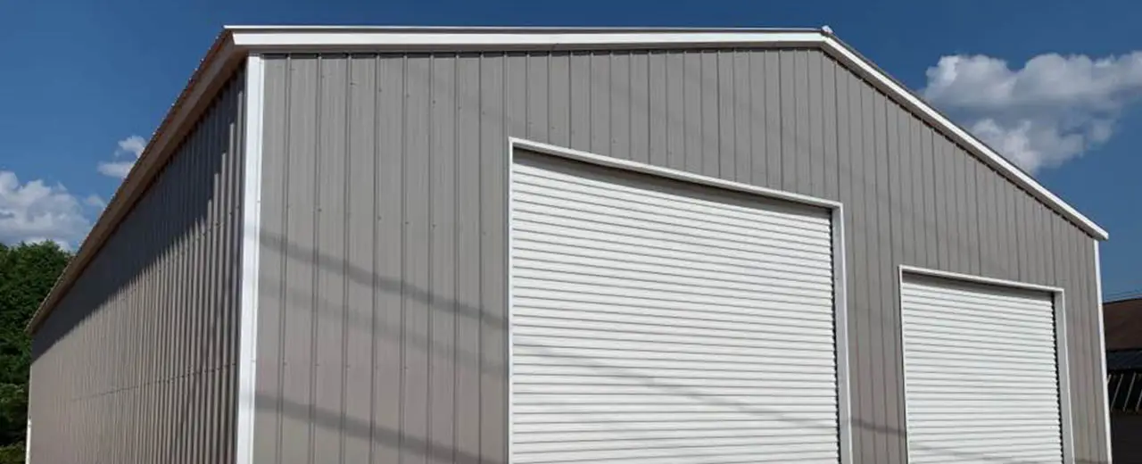 Two bay steel building garage with white trim, vertical metal roofing and vertical siding.